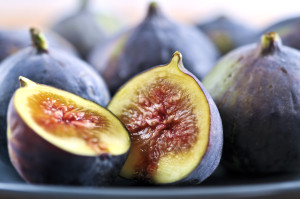 Closeup view of figs sliced in half on a blue plate