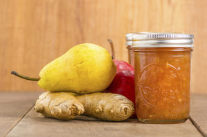 Pear ginger jam in mason jars with red and yellow pears
