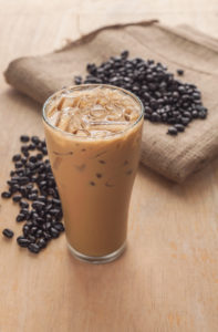 Ice coffee with fresh coffee on a wooden background