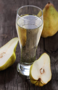 Pear cider and pears on rustic wooden table