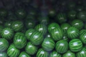 Close up of green candy gum balls in candy machine
